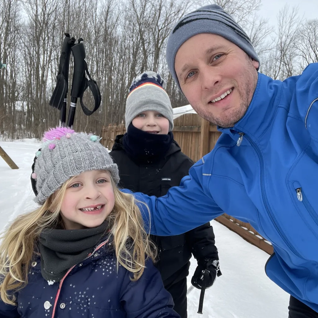 Dan with his two kids playing the snow. 